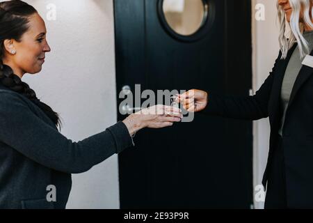 Frau Immobilienmakler geben Frau Schlüssel Stockfoto