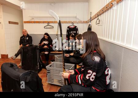 Mädchen Hockey-Team und Trainer in Umkleidekabine Stockfoto