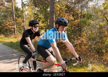 Sehbehinderte Triathlet-Frau trainiert mit ihr auf dem Tandem-Fahrrad Guide und Coach Stockfoto