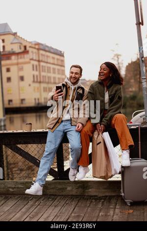 Junges Paar, das in der Nähe des Kanals in der Stadt sitzt Stockfoto