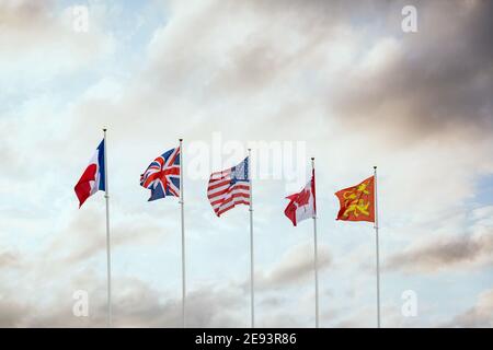 Weltkrieg zwei D-Day-Flaggen der alliierten Streitkräfte Nationen Kanada Frankreich Großbritannien und Amerika fliegen bei Sonnenuntergang weiter Französische Stadt Arramanches Gold B Stockfoto