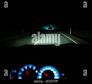 Nächtliche Fahrt auf einer dunklen Autobahn, aus Sicht des Fahrers. Stockfoto