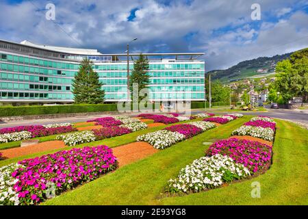 Vevey, Schweiz - 14. August 2020: Nestle Headquarter umgeben von bunten Blumen während der Sommersaison. Nestle ist das größte multinationale Unternehmen Stockfoto