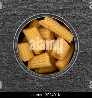 Overhead-Ansicht einer offenen Dose mit Bio-Mais auf einem grauen Schiefer Hintergrund gefüllt. Stockfoto