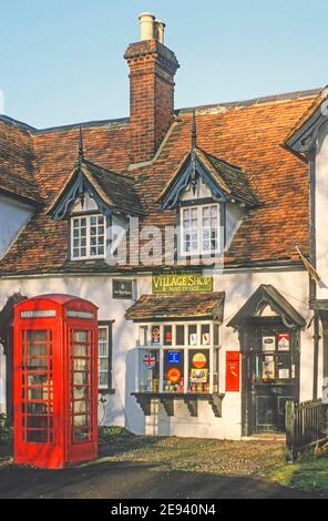 Sonniger blauer Himmel am Tag Nahaufnahme des traditionellen malerischen Dorfladen Postgebäude mit Dachfenster Wohnunterkunft Über dem kleinen Schaufenster Telefonkasten und Briefpostkasten In der Wand neben der Eingangstür Great Warley Brentwood Essex England VEREINIGTES KÖNIGREICH Stockfoto