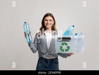 Abfallsortierung. Lächelnd Eco Volunteer Woman Holding Container Mit Leeren Plastikflaschen Stockfoto