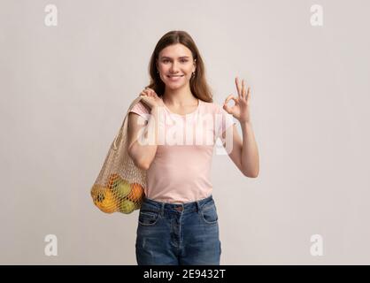 Umweltfreundliches Einkaufen. Lächelnde Frau Holding String Wiederverwendbare Tasche Mit Bio-Früchten Stockfoto