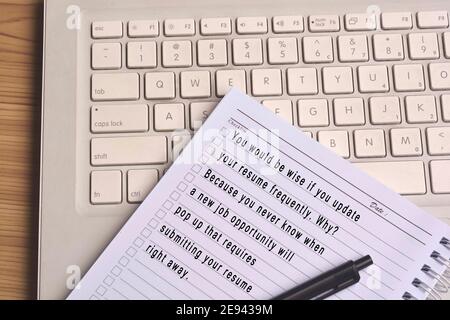 Text auf Notizblock mit Laptop Hintergrund Holztisch. Konzept der Stellenangebot Stockfoto