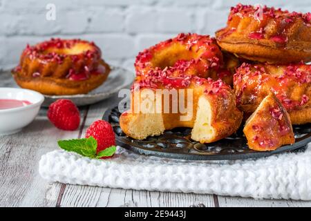 Mini Vanille Pfund Kuchen mit Himbeer-Vereisung Stockfoto