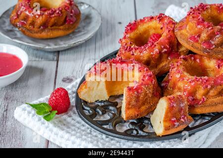 Mini Vanille Pfund Kuchen mit Himbeer-Vereisung Stockfoto