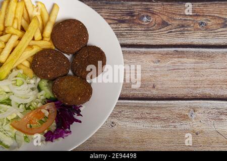 Draufsicht auf Falafels auf einem Teller mit pommes frites Und Salat Stockfoto