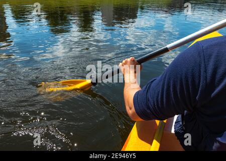 Nahaufnahme einer Person, die an einem sonnigen Tag im Fluss Kanu fahren kann. Hände halten ein Paddel und Rudern in fließendem Wasser Stockfoto