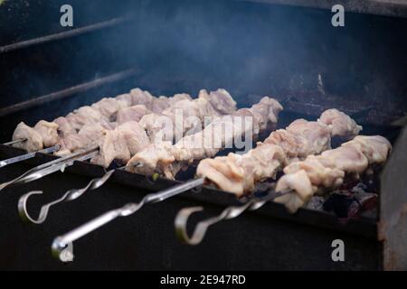 Nahaufnahme der leckeren rohen Schweinefleisch Shashlik Grillen auf dem Grill. Spieß Fleisch Kochen über Feuer und Rauch. Niemand Stockfoto