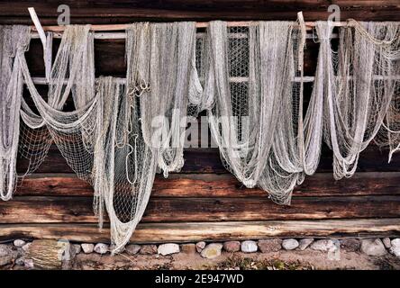 Fischernetze, die an einer Wand einer alten Holzscheune hängen. Stockfoto