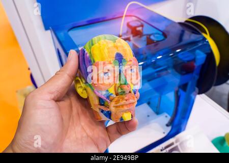 Modell gedruckt auf 3d-Drucker in Form von bunten Muskeln Des Gesichts mit menschlicher Hand, additiven Technologien und futuristischem Konzept Stockfoto