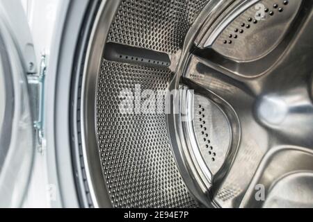 Reinigen Sie Die Trommel Der Waschmaschinen Aus Edelstahl In Nahaufnahme. Waschtechnologien und Gerätewartung. Stockfoto