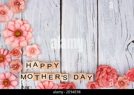 Happy Mothers Day Holzblöcke mit rustikalem Papier Blume Boden Eckrand auf weißem Holz Hintergrund Stockfoto