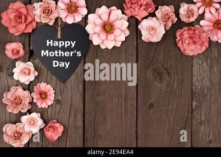 Happy Mothers Day Kreidetafel Herz mit rustikalen Papier Blume Ecke Grenze über einem Holzhintergrund Stockfoto