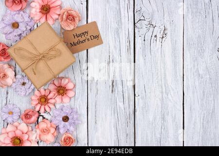 Seitenrand von Papierblumen mit Muttertag Geschenkbox Und Tag vor einem rustikalen weißen Holz Hintergrund Stockfoto