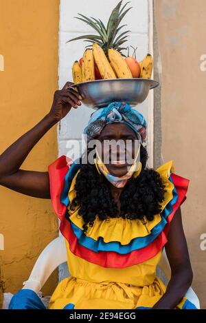 Cartagena, Kolumbien Februar 2021: Frauen Obsthändler Obstverkäufer Frau namens Palenquera trägt Gesichtsmaske während der Pandemie COVID 19 Reise Stockfoto