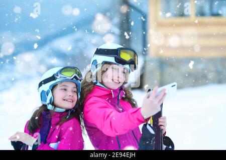 Junge Mädchen machen Selfie auf einer Skipiste in Winter Stockfoto