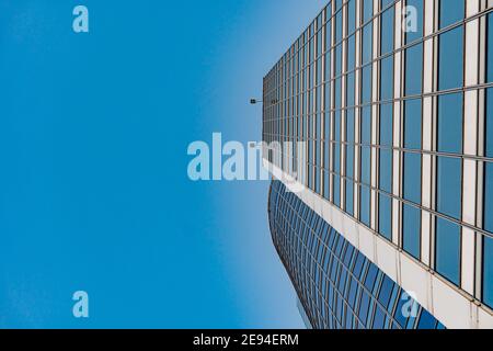 Minsk, Weißrussland - 01. Februar 2021: Blick von unten auf moderne Wolkenkratzer im Geschäftsviertel gegen blauen Himmel Stockfoto