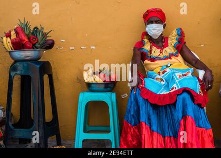 Cartagena, Kolumbien, Februar 2021: Obstverkäufer namens Palenquera tragen während der Pandemie COVID 19 eine Gesichtsmaske. Besuchen Sie Columbia Stockfoto