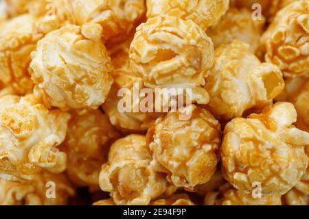 Popcorn in Karamell Glasur Nahaufnahme als Hintergrund. Köstliches Lob für das Ansehen von Filmen, Serien, Cartoon. Nahaufnahme Stockfoto