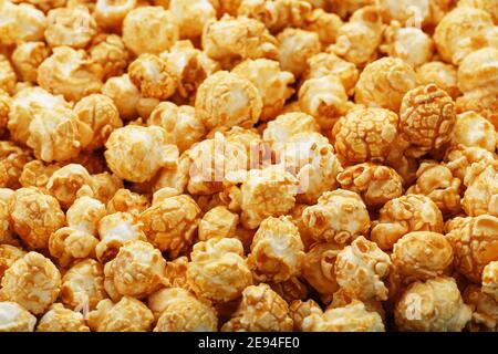 Popcorn in Karamell Glasur Nahaufnahme als Hintergrund. Köstliches Lob für das Ansehen von Filmen, Serien, Cartoon. Nahaufnahme Stockfoto