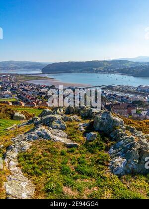 View looking down over Deganwy and the mouth of the River Conwy in Conwy North Wales from the ruins of Deganwy Castle with rocks in foreground. Stockfoto