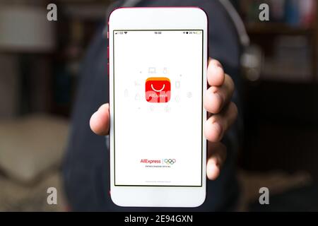 BADAJOZ, SPANIEN - 27. Jan 2021: Nahaufnahme einer Hand, die ein Smartphone mit dem Ali Express-Startbildschirm hält. Stockfoto
