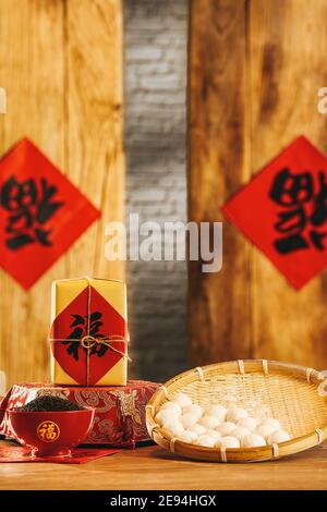 Winnowing Korb mit Klebstoff Puddings und eine Schüssel schwarz Sesamsamen - chinesisches Neujahrskonzept Stockfoto