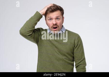 Kaukasischer Mann denken versuchen, sich an etwas zu erinnern, verwirrt, auf der Suche nach der richtigen Antwort. Negative Emotionen, Mimik. Stockfoto