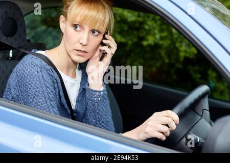 Frau, die zwar mit Handy Stockfoto