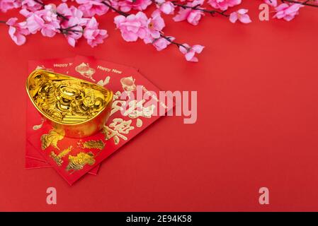 Sakura Blossom, rote Umschläge und goldene Ingot auf rotem Hintergrund Stockfoto