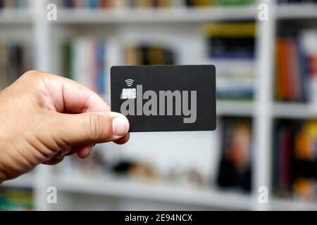 Schwarze kontaktlose Kredit- oder Debitkarte mit kontaktlosem Schild. Digitales Zahlungssystem. Stockfoto