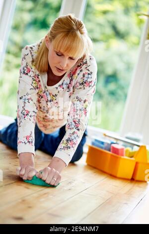 Frau mittleren Alters putzt Stockfoto