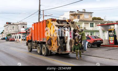 Ein Müllabfuhr-LKW voller Arbeiter wartet an einer roten Ampel in der Central Road in Santa Clara, Kuba. Sie trinken 'Decano'-Rum, obwohl sie langweilig sind Stockfoto