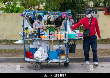 Kleinunternehmerbesitzer, der selbst gemachte Plastikartikel auf einer Stadtstraße, Santa Clara, Kuba verkauft Stockfoto