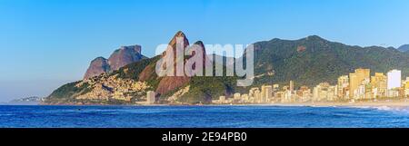 Panoramabild des frühen Morgens am Strand von Ipanema in Rio De Janeiro noch leer mit seinen Gebäuden und der Umgebung Berge Stockfoto