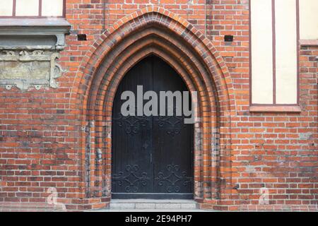 Große Doppeltüren im Bogen des alten Schlosses. Alte Architektur Europas. Stockfoto