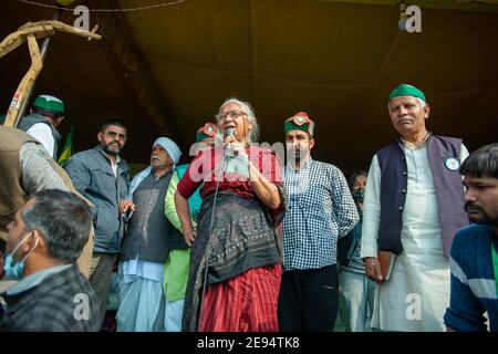 Medha Patkar, die indische Sozialaktivistin in Red Sari, wendet sich während des Protestes an die Bauern.während der Protest der Bauern gegen die drei Farmhandlungen an der Grenze zu Ghazipur fortgesetzt wird, versiegelte die Polizei in Delhi die Grenze mit Barrieren, Betonwänden und Stacheldraht, um Bauern davon abzuhalten, für ihre Proteste darauf zuzugreifen. Stockfoto