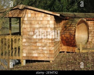 Wunderschön gearbeitetes, neu gebautes Vogelfelltier aus Holzschindeln; am Ufer des Sees auf dem Castle Ashby Anwesen in Northamptonshire. Stockfoto