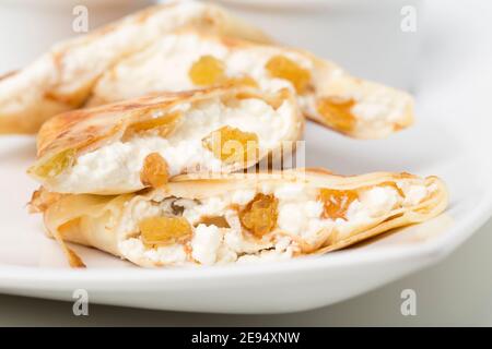 Pfannkuchen gefüllt mit Hüttenkäse und Rosinen. Nahaufnahme. Stockfoto