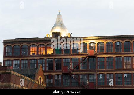 Birn Mill, Bredbury, Stockport in der Abenddämmerung mit Birnenkuppel auf dem Wasserturm und externe Feuerstelle. Denkmalgeschütztes Gebäude der Klasse 2. Stockfoto