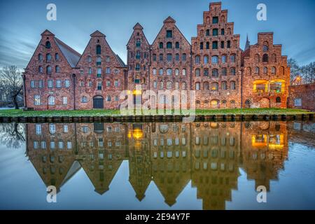 Der historische Salzspeicher spiegelt sich in der Trave bei Sonnenaufgang, gesehen in Lübeck, Deutschland Stockfoto