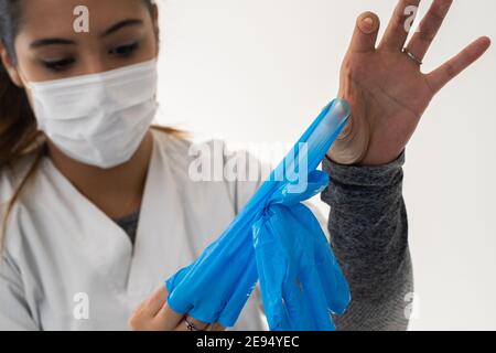 Krankenschwester, die Latexhandschuhe nach der Pflege eines covid Patienten entfernt Stockfoto