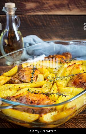 Köstliches gebackenes Huhn mit Kartoffeln auf Holzhintergrund Stockfoto