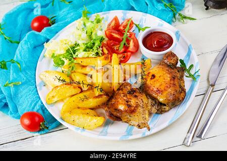 Köstliches gebackenes Huhn mit Kartoffeln auf Holzhintergrund Stockfoto