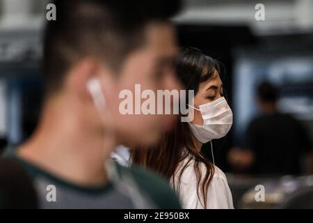 Eine Frau mit Schutzmaske als Vorsichtsmaßnahme gegen die Coronavirus-Krankheit queus, in einen Zug in Manila, Philippinen zu steigen. Stockfoto